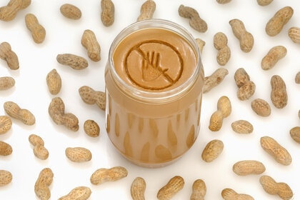 A concept photograph of a no entry or prohibited sign engraved into a jar of peanut butter.