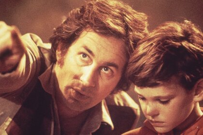 1982: American film director and producer Steven Spielberg (left) points to something in the distance as he directs American actor Henry Thomas in a scene on the set of his film, 'E.T. the Extra-Terrestrial'.