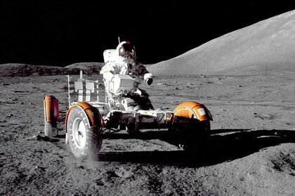An image of Commander Eugene A. Cernan in a spacesuit driving a Lunar Roving Vehicle on the moon