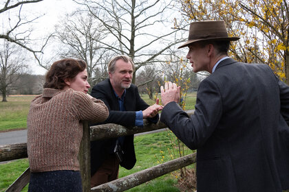 Emily Blunt (as Kitty Oppenheimer) with writer, director, and producer Christopher Nolan and Cillian Murphy (as J. Robert Oppenheimer) on the set of OPPENHEIMER.