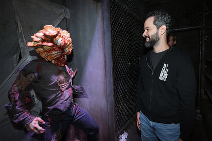 Neil Druckmann admires a The Last of Us monsters at the Opening Night Celebration of Halloween Horror Nights at Universal Studios Hollywood