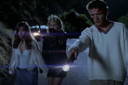 Julie James (Jennifer Love Hewitt) and Helen Shivers (Sarah Michelle Gellar) look in fear as Barry William Cox (Ryan Phillippe) points a flashlight to the ground.