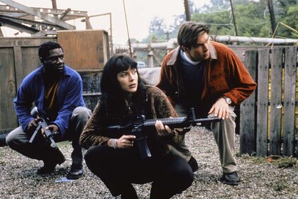 (l-r) Cleavant Derricks as Rembrandt 'Crying Man' Brown, Kari Wuhrer as Capt. Maggie Beckett, Jerry O'Connell as Quinn Mallory crouch with weapons in Sliders.