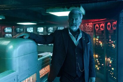 Mel Gibson as Cormac rests his hand on a machine in a control room in The Continental: From the World of John Wick Night 3.