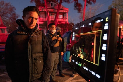 Director David Gordon Green watches a monitor while crew works on the set of Halloween Ends (2022).