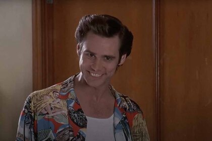 Ace Ventura (Jim Carrey) bares his teeth in a colorful shirt in Ace Ventura: Pet Detective (1994).