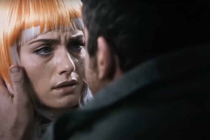 Angie (Amber Valletta) wears an orange wig as a man holds her face in Gamer (2009).