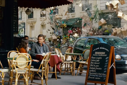 Cobb (Leonardo DiCaprio) talks to Ariadne (Elliot Page) at a cafe as reality warps in Inception (2010).