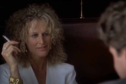 Alex Forrest (Glenn Close) wears a white suit and holds a cigarette in Fatal Attraction (1987).