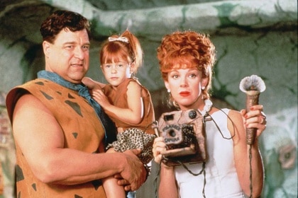 Fred holds Pebbles and Wilma Flintstone holds a camera in The Flintstones (1994).