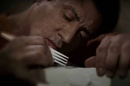 Ray Breslin (Sylvester Stallone) carves something with a plastic fork in Escape Plan (2013).
