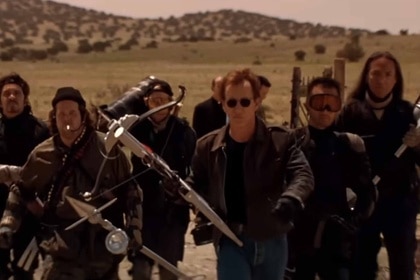 Jack Crow (James Woods) and his vampire hunting crew walk with their weapons in Vampires (1998).