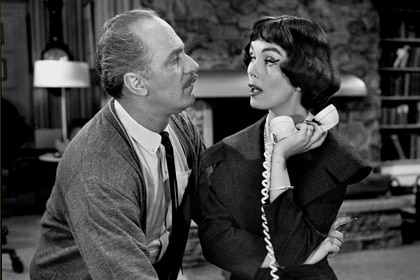 Gregory West (Keenan Wynn) leans in toward Victoria West (Phyllis Kirk) who holds a corded phone on The Twilight Zone Episode 136.