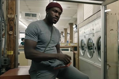 Anthony McCoy (Yahya Abdul-Mateen II) sits in a laundromat in Candyman (2021).
