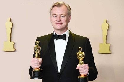 Christopher Nolan holding two Oscars at the 96th Annual Oscars.
