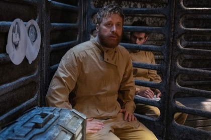 Harry Vanderspeigle (Alan Tudyk) sits in his cage next to Robert's (Paul Piaskowski) on Resident Alien Episode 401.