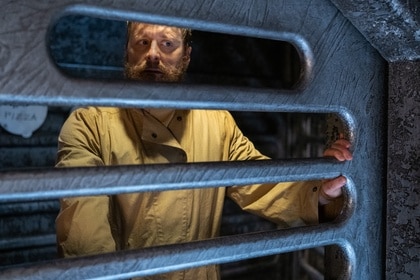 Harry Vanderspeigle (Alan Tudyk) looks through his cage bars on Resident Alien Episode 401.
