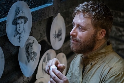 Harry Vanderspeigle (Alan Tudyk) looks at artwork of Deputy Liv on Resident Alien Episode 401.