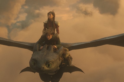 Astrid (Nico Parker) and Hiccup (Mason Thames) ride Toothless as they fly through clouds in How to Train Your Dragon (2025).
