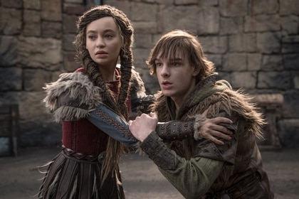 Astrid (Nico Parker) and Hiccup (Mason Thames) grab onto each other in How to Train Your Dragon (2025).