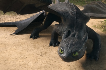 Toothless cowers on the ground in How to Train Your Dragon (2025).