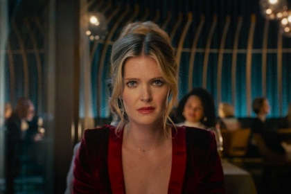 Violet sitting at a table in Drop (2025).