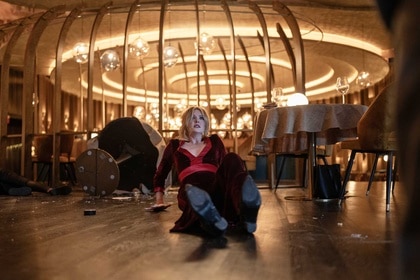 Violet crawling backwards on the floor in Drop (2025).