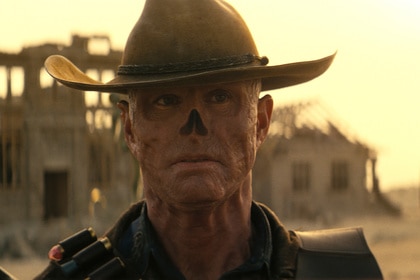 The Ghoul (Walton Goggins) wears a hat and stands in front of a dilapidated town on Fallout Season 1.