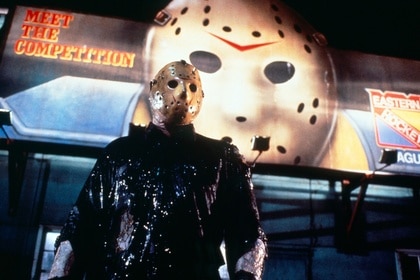 Jason Vorhees (Kane Hodder) stands in front of a hockey mask billboard in Friday the 13th Part VIII: Jason Takes Manhattan (1989)