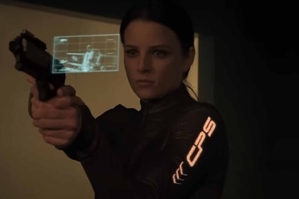 A woman holds a gun as a hologram emerges near her hand in Continuum Season 1.