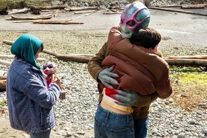 Resident Alien Harry and Max hug while Sahar and Bridget look on