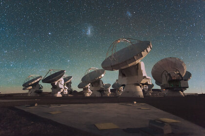 Some of the dishes comprising ALMA, the Atacama Large Millimeter/submillimeter Array in the high desert plain of Chile. The Large and Small Magellanic Clouds, companion galaxies to the Milky Way, can be seen above them. Credit: ESO/ C. Malin