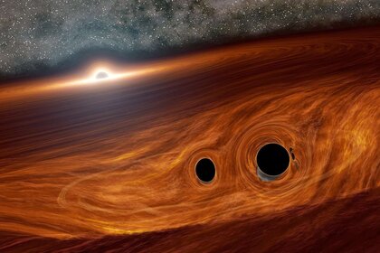 A binary pair of black holes about to merge together, near the huge disk of material swirling around a supermassive black hole in a distant active galaxy. Credit: Caltech/R. Hurt (IPAC)