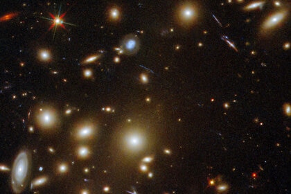 A foreground star (upper left) betrays its nature via diffraction spikes, an optical effect when a point source of light passes through a telescope.
