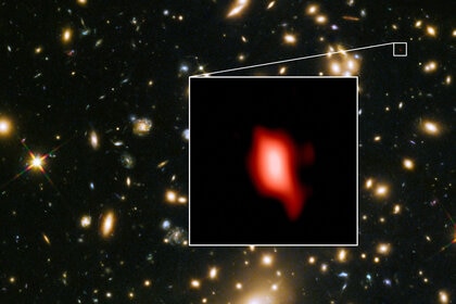 The galaxy cluster MACSJ1149.5+223 lies in the foreground and magnifies the image of the much more distant JD1, a galaxy 13.3 billion light years away. Inset is the observation of oxygen from the galaxy. 