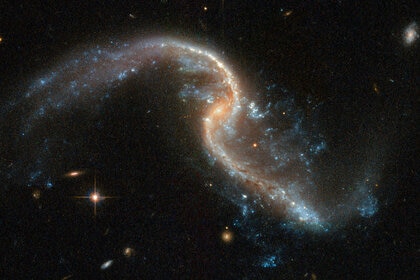 Arp 256N in more detail. Note the tidal tails and bright blue spots indicating star formation sites. Credit: ESA/Hubble, NASA