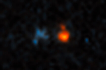 The quasar J043947.08+163415.7 (red) is extremely far away, and its light has been amplified by an intervening galaxy (blue) much closer to Earth. Credit: NASA, ESA, and X. Fan (University of Arizona)