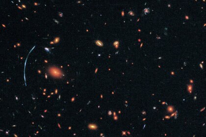 The “true” shape of the lensed galaxy (right, inset), reconstructed by mapping out the structure of the galaxy cluster and determining how it distorted the light of SGAS 1110 on its way to Earth. Credit: NASA, ESA, and T. Johnson (University of Michigan)