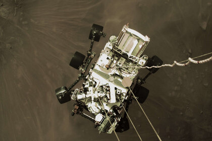 This phenomenal shot looking down from the sky crane shows the rover hanging by cables under the crane when it was about 2 meters from the surface of Mars. Credit: NASA/JPL-Caltech