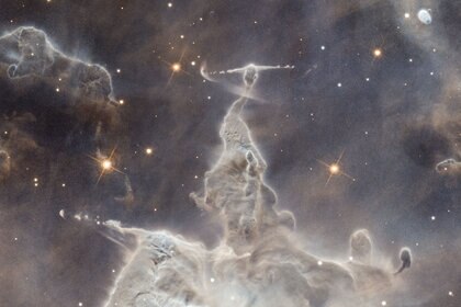 Close-up of a star-forming nebula shows a young star buried in gas and dust shooting twin beams of matter from its poles. 