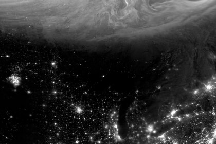 The aurora swirls in northern Canada while the lights from US cities illuminate the night… as well as something else ominously glowing in the American Upper Midwest.