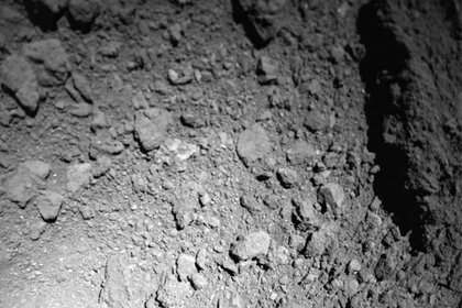 An image from the MASCOT lander as it headed down to the asteroid Ryugu. Note the shadow of the lander to the lower left (this is reversed from the original image to get light source coming from above, so rocks don’t look like pits). Credit: JAXA/DLR/CNES