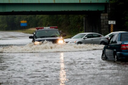 453561078-police-officer-drives-past-flooded-cars-abandoned-on.jpg