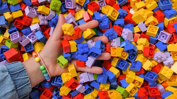 LEGO pile with hand Getty