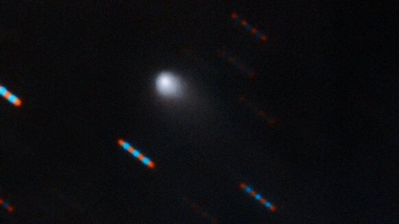The interstellar comet 2I/Borisov imaged by the massive Gemini telescope on 9-10 September 2019. The telescope tracked the comet and took several images in red and blue filters, so the stars appear as a trail of multi-colored dots. 