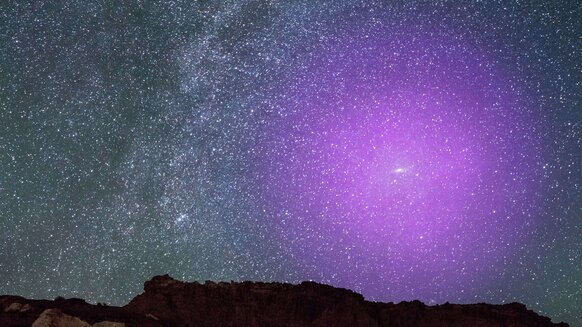 Artwork depicting the halo of the Andromeda galaxy (purple) superposed on an image of the night sky to show its scale. Credit: NASA, ESA, J. DePasquale and E. Wheatley (STScI) and Z. Levay