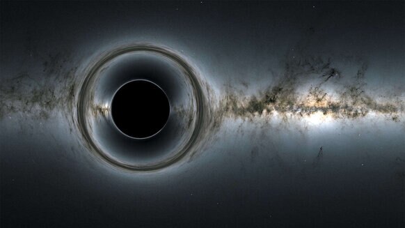 A simulated image shows what happens when a black hole’s gravity distorts the light from stars behind it. Credit: NASA