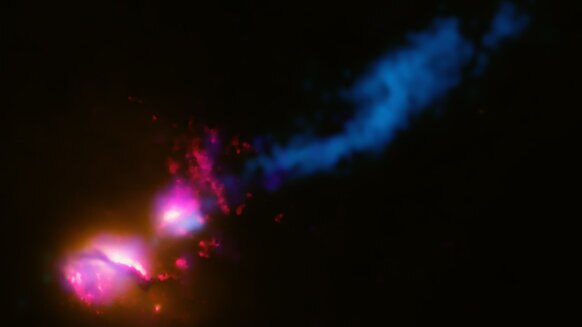 Data from across the electromagnetic spectrum are combined to show that the galaxy 3C321 (lower left) is blasting out a jet of matter that is slamming into a neighboring galaxy (middle) which deflects the jet somewhat (blue, upper right). Credit:     X-ra