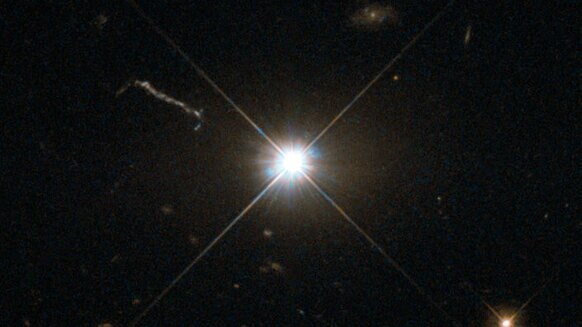 A deep Hubble image of the quasar 3C 273 shows it as a blazing point source, almost like any other star. The linear feature to the upper left is a jet of material accelerated by the quasar’s black hole central engine. Credit: ESA/Hubble & NASA