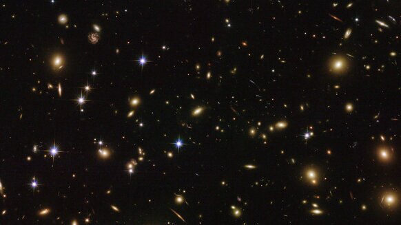 The immense galaxy cluster Abell 2163 is 2.5 billion light years away and contains hundreds of massive galaxies. Credit: ESA/Hubble & NASA